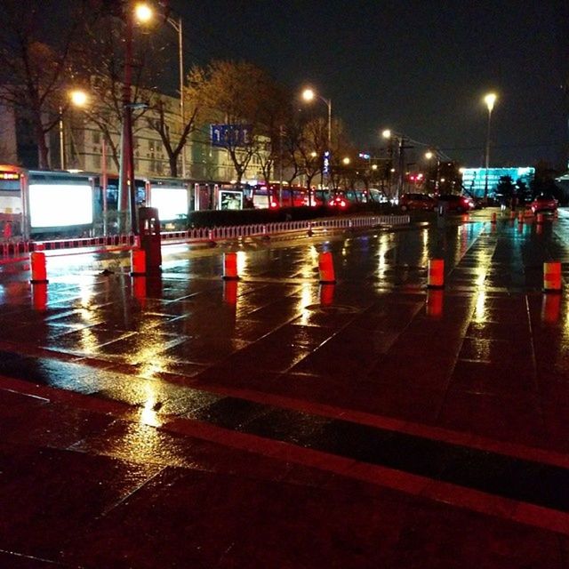 night, illuminated, transportation, street light, street, mode of transport, city, lighting equipment, road, car, land vehicle, wet, city street, city life, motion, reflection, rain, long exposure, building exterior, speed