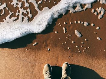 Low section of person on sand at beach