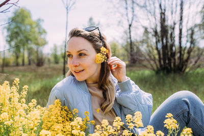 Portrait of smiling young woman sitting on field