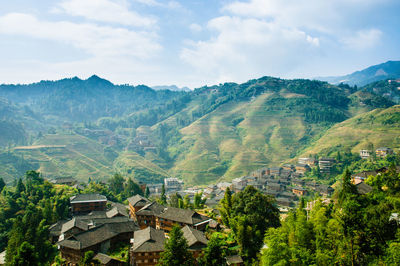 Aerial view of townscape and mountains against sky