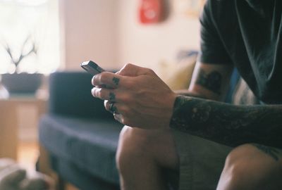 Man with tattoos using phone