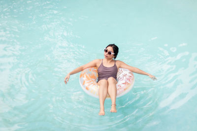 High angle view of woman in inflatable ring on pool