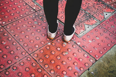 Low section of woman standing on tiled floor