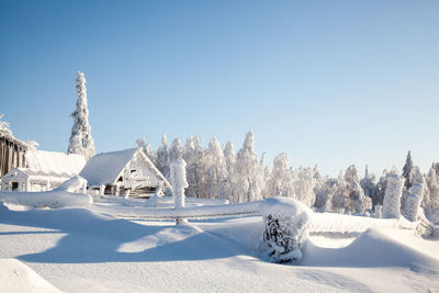 Snow covered land against clear sky