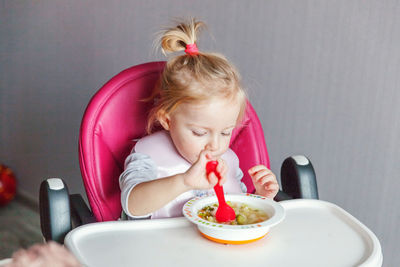 High angle view of cute girl eating food at home