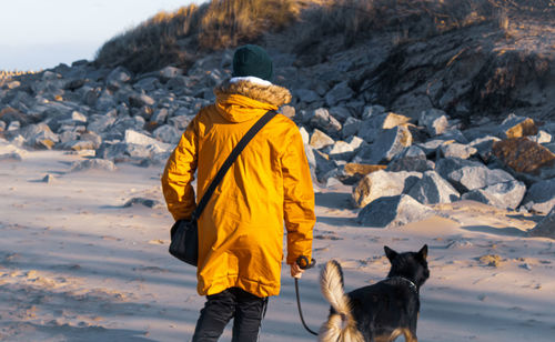 Rear view of woman with dog on snow