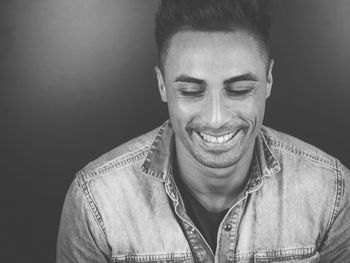 Close-up of smiling young man against gray background