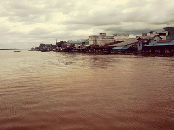 View of city by sea against sky