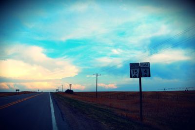 Road passing through landscape against cloudy sky