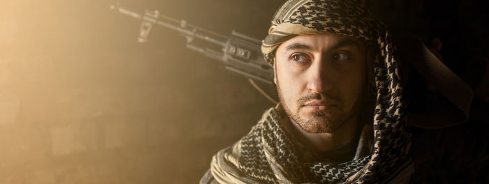 Portrait of serious middle eastern man with ak-47