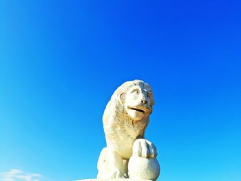 Low angle view of statue against clear blue sky