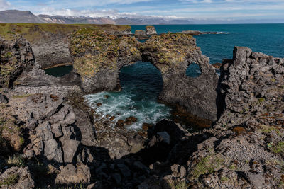 Natural rock arch and seascape against sky