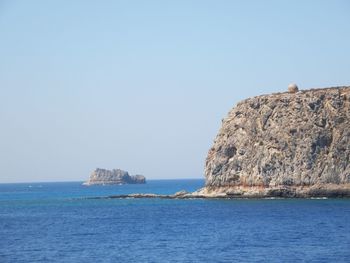 Scenic view of sea and rock formation against clear sky