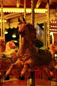 Statue in illuminated carousel at night