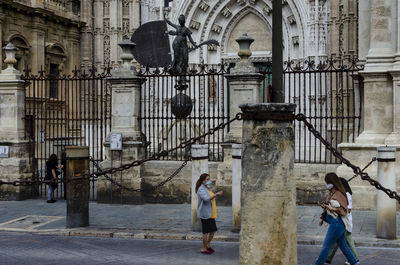 People walking on street amidst buildings in city