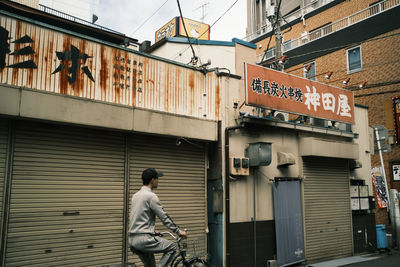 Man walking on street against building