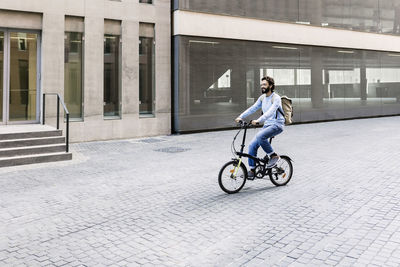 Smiling man riding bicycle in city