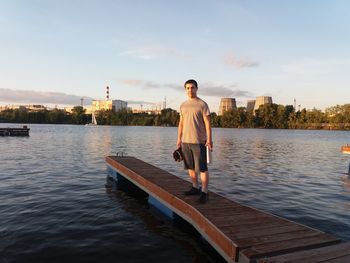 Full length of man standing on river in city against sky