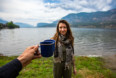 Portrait of smiling mid adult woman drinking water in lake