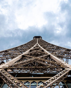 Low angle view of communications tower against cloudy sky