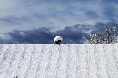 Low angle view of snow covered roof against sky