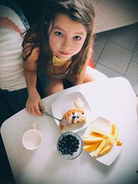 Portrait of girl having breakfast at table