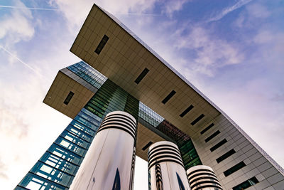 Low angle view of modern building against cloudy sky