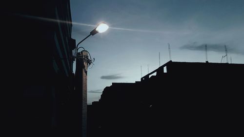 Low angle view of silhouette buildings against sky at night