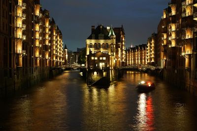 Canal passing through city at night