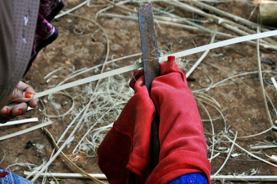 Cropped hands peeling wood outdoors