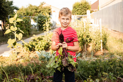 Full length of boy holding plants