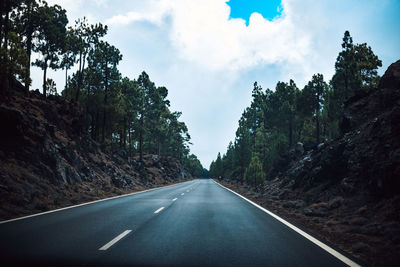 Road amidst trees against sky