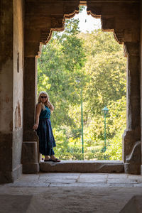 Woman standing at entrance of historic building