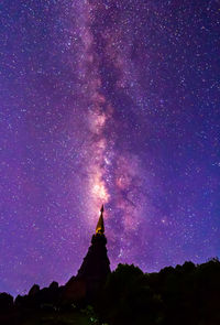 Low angle view of silhouette building against sky at night