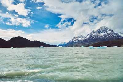 Scenic view of sea and mountains against sky