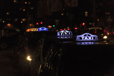 Illuminated taxis on street at night