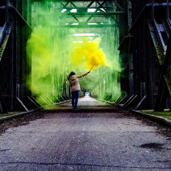 Woman holding distress flare at bridge