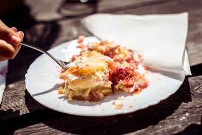 Close-up of hand having dessert in plate