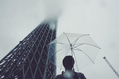 Low angle view of woman standing against sky