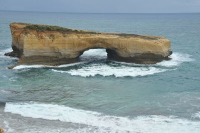 Scenic view of rocks in sea against sky