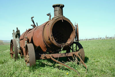 Close-up of rusty machine on grassy field