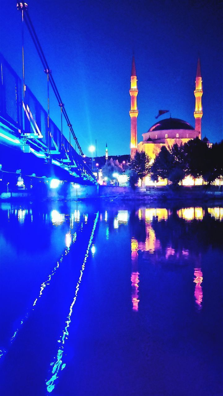 REFLECTION OF ILLUMINATED BUILDING IN WATER