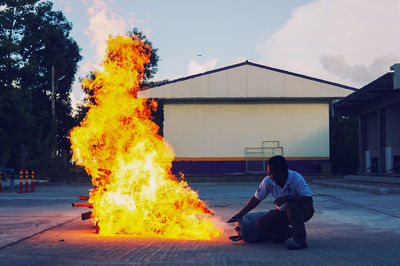 Man holding burning gas cylinder in city