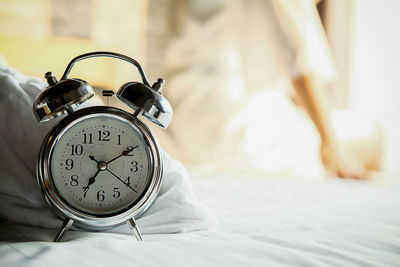 Close-up of alarm clock on bed