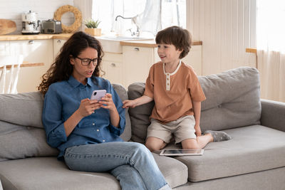 Friends sitting on sofa at home