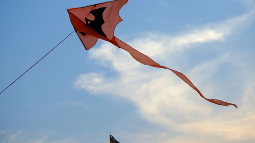 Low angle view of kites flying against sky