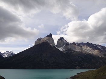 Scenic view of sea and mountains against cloudy sky