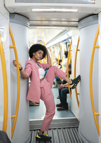 Female hipster with leg-up standing in train