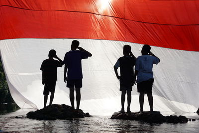 Rear view of people standing in water