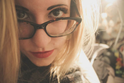 Close-up portrait of young woman wearing eyeglasses on sunny day